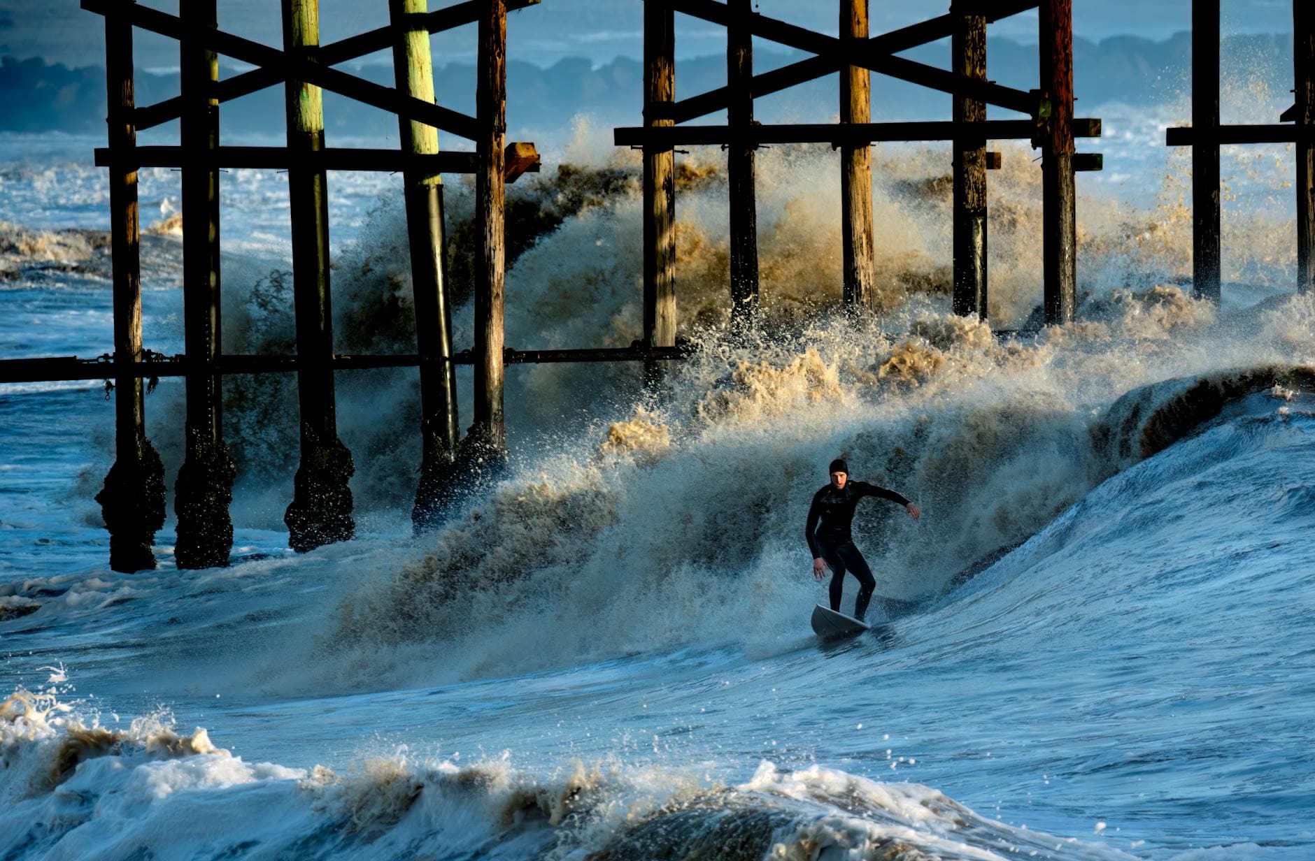 Windsurfer carving across a wave along the Southern California coast