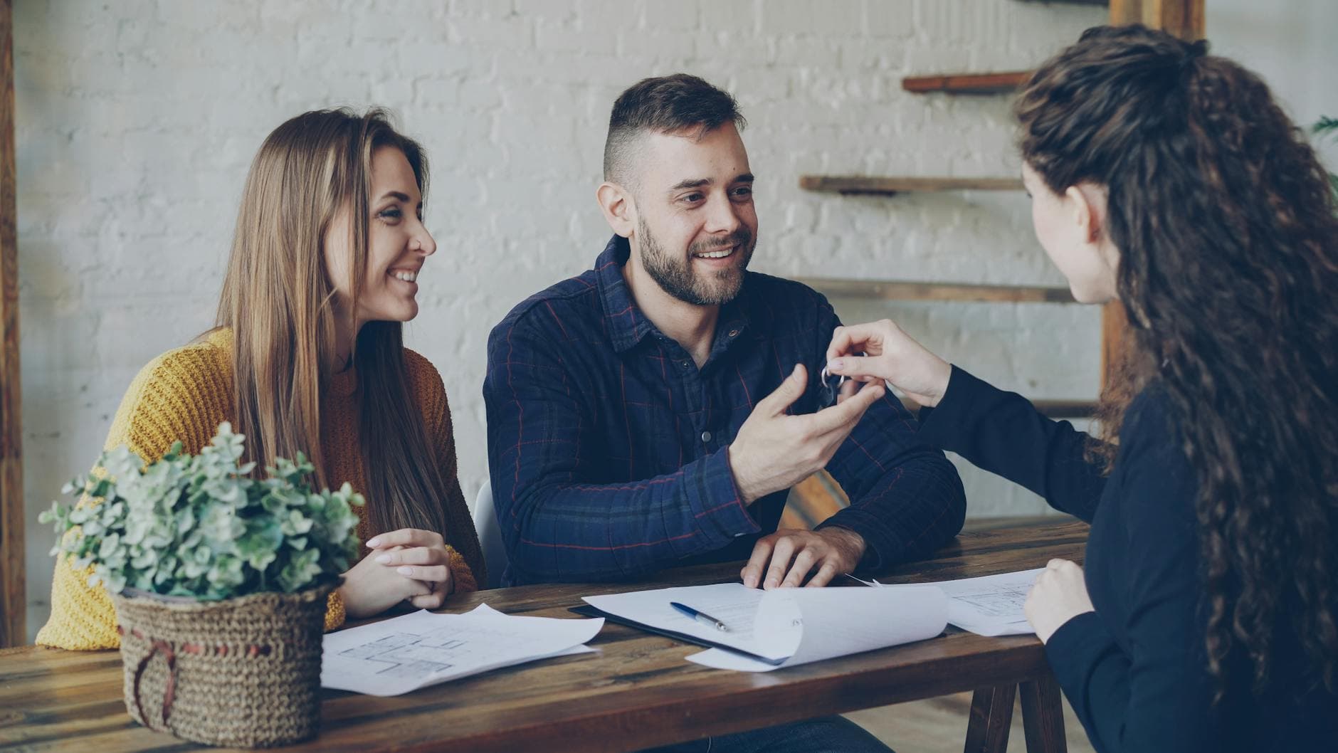 Happy couple receiving house keys from a realtor
