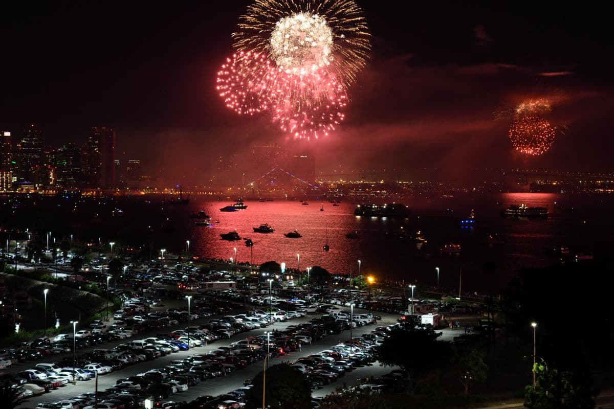Fireworks over a coastal city and harbor at night