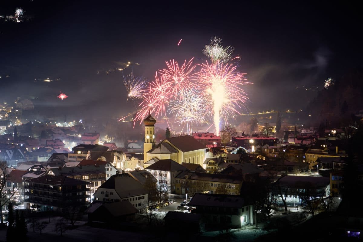 Fireworks over a stadium and hills at night