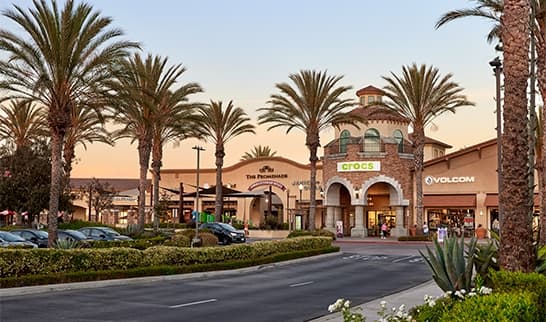 Camarillo Premium Outlets storefronts at golden hour with palm trees